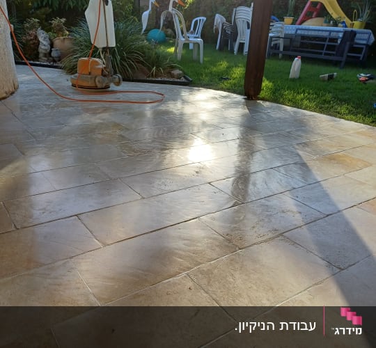 מכונת פוליש על רצפת אבן עם כבל חשמל כתום